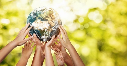 several hands holding up a globe
